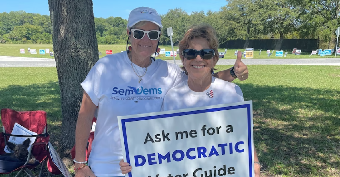Two Volunteers with Ask Me for a Democratic Voter Guide Sign